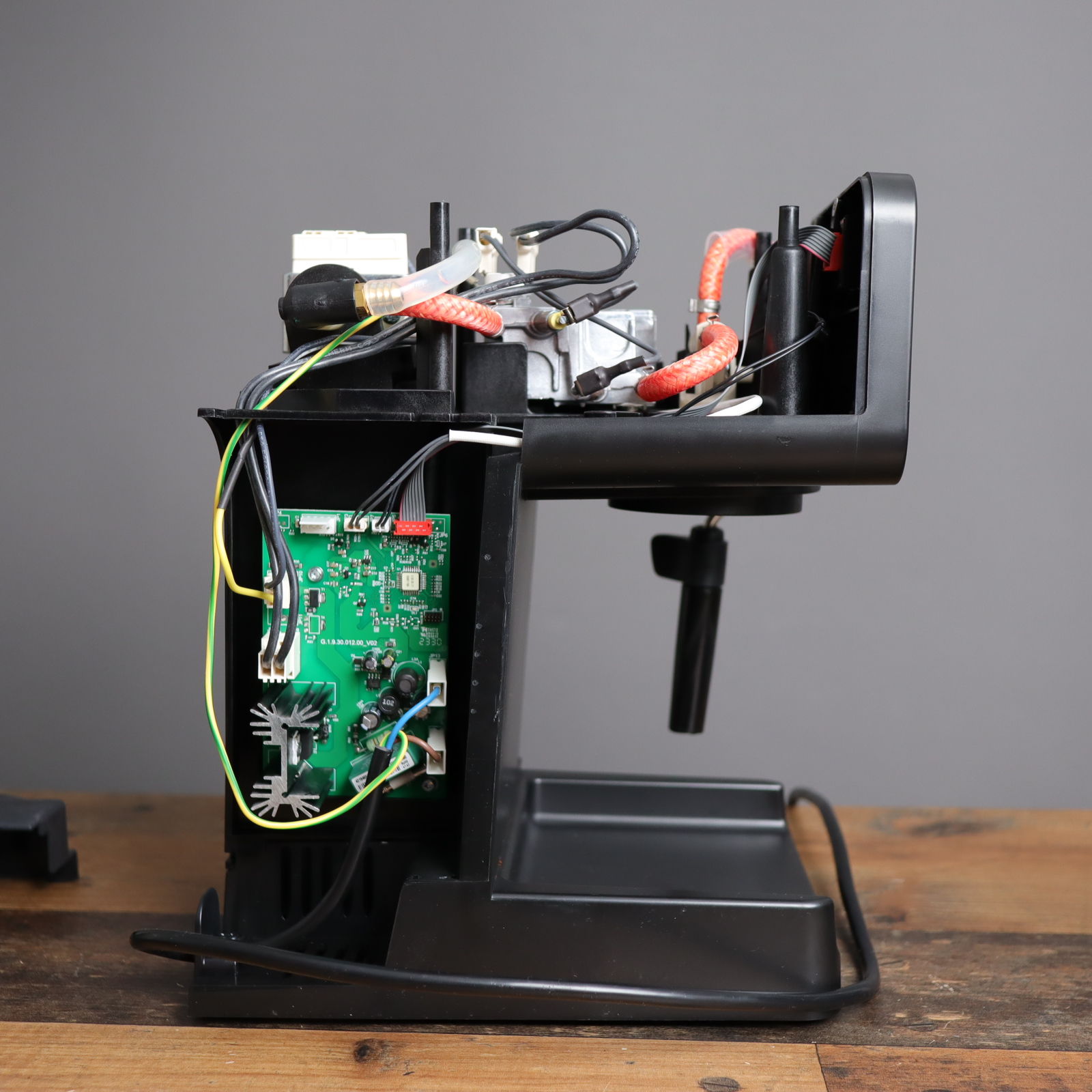 A view of the exposed Gaggia Espresso Deluxe, with view of the main board, water hoses, and wiring